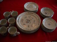 Full view of the dish set showing 6 large plates, 6 bowls, 6 cups, and 6 saucer plates with floral patterns laid on red cloth.