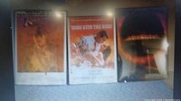 Photo showing set of three framed vintage movie posters: Indiana Jones and the Last Crusade, Come with the Wind, and Halloween.