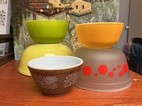 Front view showing all five bowls arranged with larger bowls in back and smaller in front, various colors and designs visible.