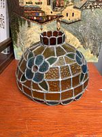 Side view showing floral and geometric stained glass pattern in brown, amber, blue, and green hues