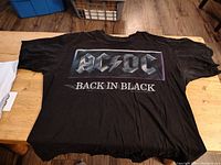 Front side of black vintage AC/DC Back In Black large t-shirt showing metallic style logo and text.