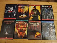 Top-down image of 8 Friday the 13th DVDs arranged on a wooden surface. Covers show various parts of the series, including Freddy vs Jason.
