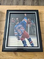 Front view of 8x10 framed print showing Wayne Gretzky in New York Rangers uniform with number 99, mid-motion on ice rink.