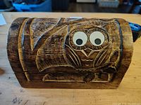 Front side of handmade wooden box showing carved owl design with googly eyes.