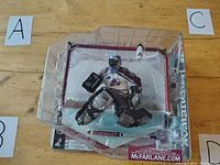 Front view of McFarlane NHL Patrick Roy action figure inside hockey net in original plastic packaging