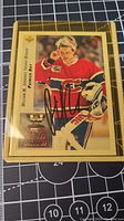 Front side of the Patrick Roy William M. Jennings Trophy Winner hockey card signed in black ink, showing him in Montreal Canadiens goalie gear.