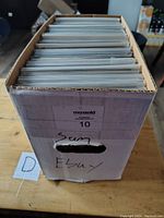 Photo of white short box filled with upright comic books protected in clear sleeves.