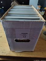 Box of comics viewed from the handle side showing a packed white short box full of comic books in sleeves.