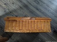Top view of closed wicker basket showing snap closure and leather strap
