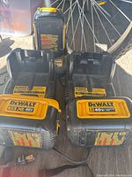 Photo showing two DeWalt battery chargers and four 40V MAX XR batteries in black and yellow colors.
