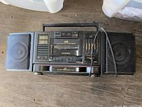 Full front view of JVC boombox showing two detachable speakers, cassette player, CD player, tuner, and equalizer sliders.