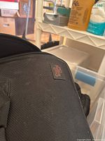 Close-up of black Pampered Chef fabric bag with label showing brand