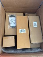 Box containing several unopened Pampered Chef items in original packaging