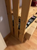 Close-up of vertical wood slats with screws showing the structure of the shelf.