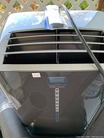 Front top view showing Danby Premiere portable air conditioner with air vents and remote control bag on top.