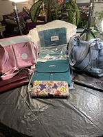 Full lot display showing 2 purses, several wallets, and 3 cosmetic bags clustered on table.