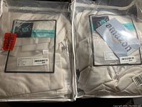 Curtain panels in clear packaging showing folds and label with sticker price.