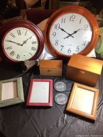 Two wall clocks, three picture frames, two wooden boxes, two slate coasters shown flat, and a rock with an exposed geode cut visible.