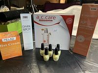 Photo of packaged skincare and nail care products including A.C. Care Bee Venom Toner, Vigority KP Bump Eraser Body Scrub, Dark Spot Corrector, Melao Hot Cream, and five mini OPI Nail Envy Strengtheners.