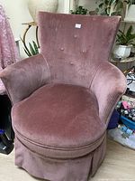 Front view of vintage pink corduroy upholstered bedroom chair showing the seat, back, and arms.