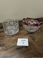 Front view of two crystal bowls, one clear and one with ruby red overlay showing intricate cut patterns.