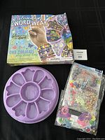 Photo showing damaged box of Friendship Word Wear bead craft kit, purple bead tray, and packet of beads and thread.