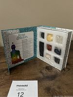 Opened decorative box with 7 chakra stones secured in foam, along with black pouch inside.