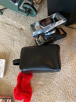 Jeanie Rub massager with attached power cord and black carrying case on carpeted floor.