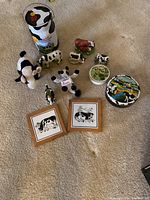 Overview of the cow memorabilia showing stuffed animals, figurines, tins, and framed artworks