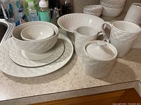 All items arranged showing the plates, bowls stacked, cups, creamer, sugar bowl, and vegetable bowl displaying the pattern and condition.