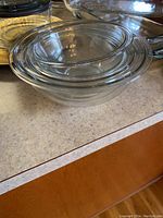 Nested clear glass Pyrex mixing bowls of different sizes stacked together on a countertop.