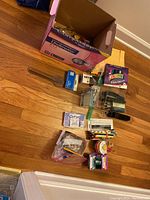 Overview photo of a box filled with office supplies and assorted supplies laid on floor