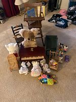 Photo of the entire assorted toy lot including the Schoenhut wooden piano, two wooden high chairs, and various plush stuffed animals and figurines arranged on carpet.