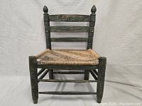 Front view of antique wooden ladder back chair with rush woven seat showing overall wear and condition.