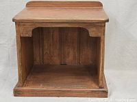 Front view showing the open storage compartment and wooden plank back panel