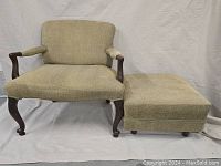 Wide view of French walnut armchair alongside matching footstool showing overall design, upholstery, carved legs with clawed ball feet and condition.