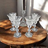 Overall view of six glasses and decanter on wooden table