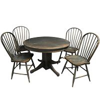 Front view of round table surrounded by four Windsor chairs on studio background