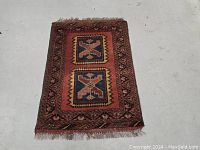 Full view of the Afghan runner rug laid flat showing the geometric patterns and color scheme.