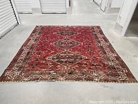 Full view of red Shiraz rug laid flat in storage unit