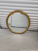 Full view of the round giltwood mirror showing overall size and ornate frame.