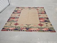 Full rug laid out on concrete floor from an elevated angle showing full rug and pattern detail.