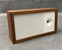 Front view of Awair indoor air quality monitor showing wooden frame and white perforated panel with circular sensor.