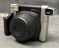 Front-left angle view showing lens barrel, flash unit, grip