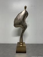 Front view of modern metal abstract sculpture on square metal base.