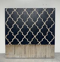 Front view of the painting showing black and beige quatrefoil pattern above a textured beige section with vertical lines.