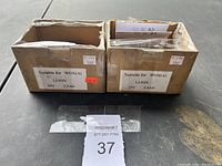 Two cardboard boxes containing lithium-ion batteries labeled Suitable for WOX(A), 20V, 2.5AH.