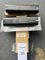 Two new Makita black power tool batteries ML-9000 on cardboard boxes with protective bubble wrap, showing overall condition and packaging.