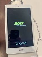 Front view of Acer tablet powered on showing Acer logo and Powered by Android text on screen.