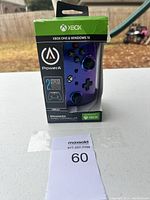 Front view of PowerA enhanced wired controller in packaging, showing purple controller through window, Xbox and Windows 10 compatibility